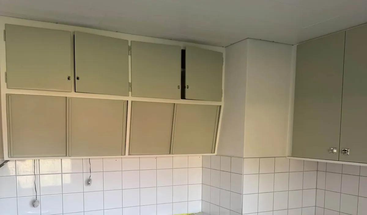 Kök med salviagröna skåpluckor och vitt kakel